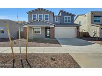 Charming two-story home with a two-car garage and neutral colored exterior at 17313 W Via Dona Rd, Surprise, AZ 85387