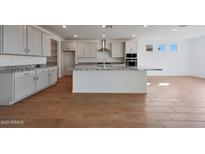 Beautiful kitchen with a large island featuring granite countertops, white cabinets, and stainless steel appliances at 17445 W Via Dona Rd, Surprise, AZ 85387