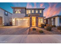 Inviting two-story home featuring a stone pillar entrance, a two car garage, and a beautiful paver driveway at 25582 S 224Th Way, Queen Creek, AZ 85142