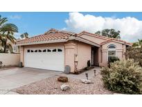 Charming single-story home featuring a two-car garage, tile roof and low maintenance landscaping at 4013 E Woodland Dr, Phoenix, AZ 85048