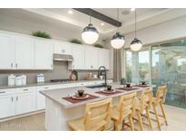 Bright kitchen features white cabinets, sleek countertops, and a large island with seating at 43720 N Acadia Way, New River, AZ 85087