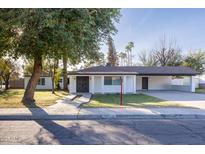 Charming home featuring an inviting front yard with mature trees and a covered parking area at 8002 N 5Th Ave, Phoenix, AZ 85021