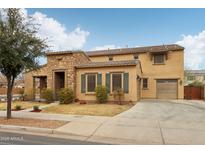 Charming two-story home featuring a stone facade, two-car garage, and well-maintained landscaping at 20916 E Via De Arboles --, Queen Creek, AZ 85142