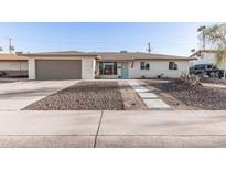 Charming single-story home with desert landscaping, a two-car garage, and a light blue front door at 7923 E Palm Ln, Scottsdale, AZ 85257