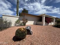 Landscaped front yard featuring desert flora, including barrel cactus, complemented by decorative gravel at 9059 N Arroya Grande Dr, Phoenix, AZ 85028