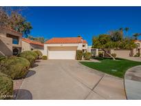 Charming single-story home featuring a tile roof, a two-car garage and a well-manicured front yard at 10056 E San Bernardo Dr, Scottsdale, AZ 85258