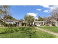 Charming single-story home with a well-manicured lawn and inviting stone pathway at 1018 W Kaler Dr, Phoenix, AZ 85021