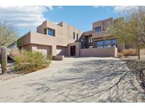 Striking modern home featuring a sand-colored stucco exterior, clean lines, and a spacious driveway leading to an attached garage at 11097 Quinn Dr, Goodyear, AZ 85338