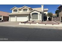 Charming two-story home with a three-car garage, desert landscaping, and a welcoming arched entry at 1478 E Spur Ave, Gilbert, AZ 85296