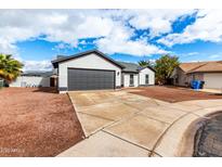 Charming home showcasing modern exterior with gray garage and neutral paint with spacious driveway and desert landscaping at 16422 S 45Th Pl, Phoenix, AZ 85048