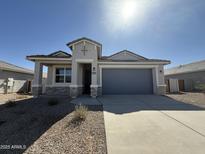 Charming single-story home featuring a well-maintained facade and two car garage in a sunny neighborhood at 36001 W San Ildefanso Ave, Maricopa, AZ 85138