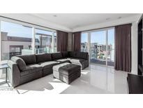 Bright living room featuring a sectional sofa, ottoman, floor-to-ceiling windows, and elegant tile floors at 4422 N 75Th St # 6007, Scottsdale, AZ 85251