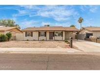 Single-story home with desert landscaping, covered carport and cozy charm at 6031 W Hearn Rd, Glendale, AZ 85306