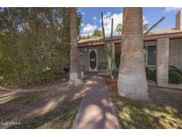 Charming single-story home with a brick pathway and mature trees leading to a welcoming front door at 6854 W Wagoner Rd, Glendale, AZ 85308