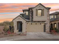 Charming two-story home with stone accents, a two-car garage, and a welcoming arched entryway at 9556 W Sells Dr, Phoenix, AZ 85037