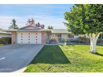 Inviting single-story home with well-kept lawn, charming curb appeal, and a two-car garage at 10825 W Caron Dr, Sun City, AZ 85351