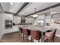 Bright kitchen with island seating, stainless steel appliances, and abundant counter space at 13211 W Hummingbird Ter, Peoria, AZ 85383
