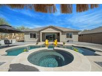 Inviting backyard pool and spa with bright yellow Adirondack chairs, perfect for relaxing and enjoying the sunny weather at 18267 W Verdin Rd, Goodyear, AZ 85338