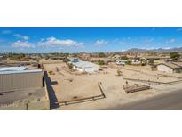 Wide aerial shot of home with white exterior, solar panels, large yard, and mountain views at 2038 S 221St Ave, Buckeye, AZ 85326