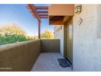 View of the front porch with stucco walls and a decorative pergola, offering a cozy outdoor space at 3434 E Baseline Rd # 213, Phoenix, AZ 85042