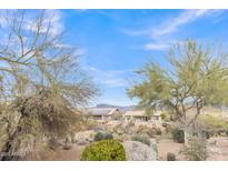 Desert home features desert landscaping, a backyard patio, and mountain views at 8096 E Lavender Dr, Gold Canyon, AZ 85118