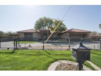 Charming single-story home featuring lush front yard and a secure black metal gate entrance at 1107 W Tamarisk St, Phoenix, AZ 85041