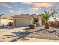 Charming single-story home featuring a well-manicured front yard and neutral color palette at 16875 W Manchester Dr, Surprise, AZ 85374