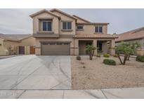 Two-story home with a two car garage, gravel yard and covered porch at 17757 W Acapulco Ln, Surprise, AZ 85388