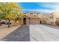 Charming two-story home with stone accents, a well-manicured lawn, and a spacious two car garage at 22157 W Moonlight Path, Buckeye, AZ 85326