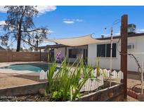 A backyard with a refreshing pool and a cozy covered patio for outdoor relaxation at 2230 W Peralta Ave, Mesa, AZ 85202