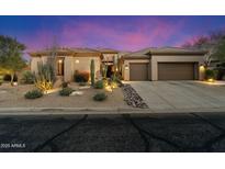 Charming single-story home featuring desert landscaping, multiple car garage, and inviting curb appeal at dusk at 33705 N 64Th St, Scottsdale, AZ 85266