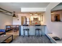 Bright kitchen featuring a breakfast bar with seating, stainless appliances, and an open dining area at 461 W Holmes Ave # 308, Mesa, AZ 85210