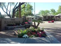 Community entrance with signage, colorful flower beds and lush landscaping on a sunny day at 5345 E Van Buren St # 111, Phoenix, AZ 85008