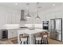 Bright kitchen featuring white cabinets, stainless steel appliances, and a central island with bar stool seating at 8043 E Jaeger St, Mesa, AZ 85207