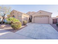 Charming home featuring a three-car garage, desert landscaping, and a well-maintained exterior at 15993 W Poinsettia Dr, Surprise, AZ 85379