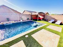 Stunning backyard pool featuring lush turf, comfortable lounge chairs, and a tranquil water feature, creating a private retreat at 21255 W Ashland Ave, Buckeye, AZ 85396