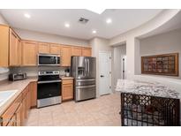 Well-lit kitchen featuring stainless steel appliances, light wood cabinetry, and tile flooring at 2951 W Plum Hollow Dr, Anthem, AZ 85086