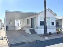 Inviting mobile home with an attached carport, neat landscaping, and a welcoming facade at 455 S Jaspar Dr, Apache Junction, AZ 85119