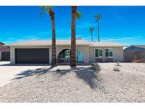 Charming single-story home featuring a well-manicured yard and attached garage, complete with blue accent door at 4713 W Kelton Ln, Glendale, AZ 85306