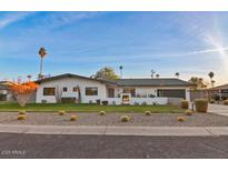 Charming home featuring modern design, desert landscaping, well-manicured lawn and integrated outdoor fireplace at 521 W Stella Ln, Phoenix, AZ 85013