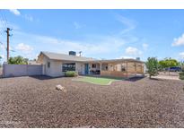 Charming single-story home featuring a low-maintenance yard, putting green, and covered patio for outdoor living at 6943 E Granada Rd, Scottsdale, AZ 85257