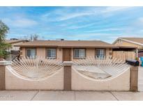 Charming single-story home featuring a decorative front fence and well-maintained front yard at 7017 W Beatrice St, Phoenix, AZ 85043