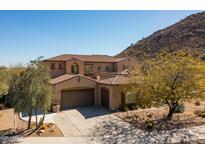 Beautiful two-story home featuring a tile roof, three-car garage, desert landscaping, and mountain views at 8667 W Lariat Ln, Peoria, AZ 85383