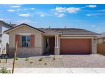 Inviting single-story home featuring desert landscaping, a brick-accented facade, and a brick paver driveway at 14777 W Soft Wind Dr, Surprise, AZ 85387