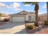 Charming single-story home with a two-car garage, desert landscaping, and a mature palm tree at 15911 W Carmen Dr, Surprise, AZ 85374