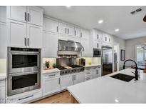 Bright kitchen features stainless steel appliances, custom cabinets, and a spacious island with quartz countertops at 3812 E Parkside Ln, Phoenix, AZ 85050