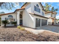 Charming two-story home showcasing a terracotta roof, gray garage doors, and desert landscaping at 4805 E Monte Cristo Ave, Scottsdale, AZ 85254