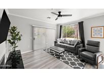 Bright living room featuring a comfortable gray sofa, stylish patterned rug, and sliding glass doors at 5345 E Van Buren St # 141, Phoenix, AZ 85008