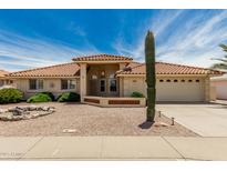Charming single-story home with a red tile roof, desert landscaping, and an attached two car garage at 8303 E Monterey Ave, Mesa, AZ 85209