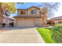 Two-story home with a two-car garage, green grass, and desert landscaping at 1043 W Washington Ave, Gilbert, AZ 85233